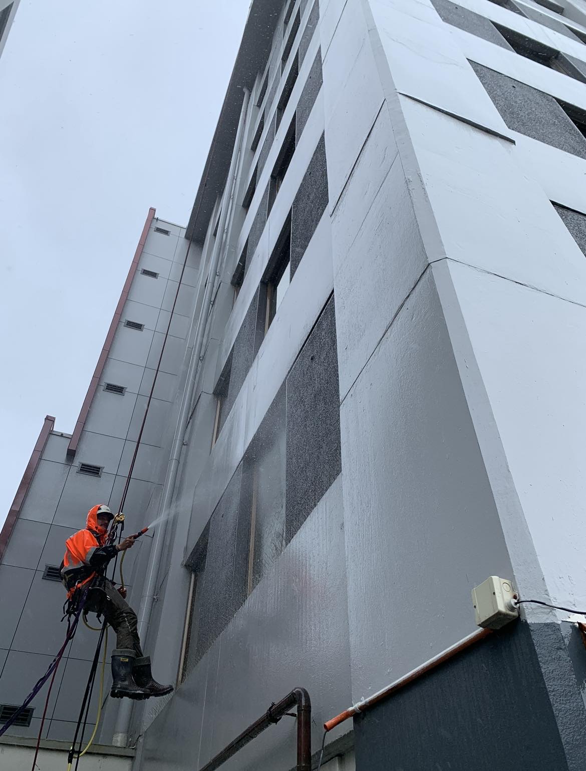 Professional window cleaner working on a high-rise building